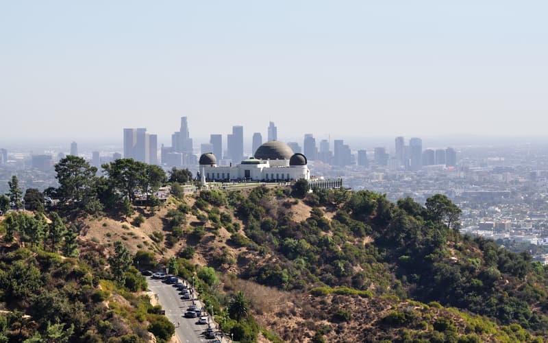 Das Griffith Observatory über dem Becken von Los Angeles, dahinter die Skyline von Downtown